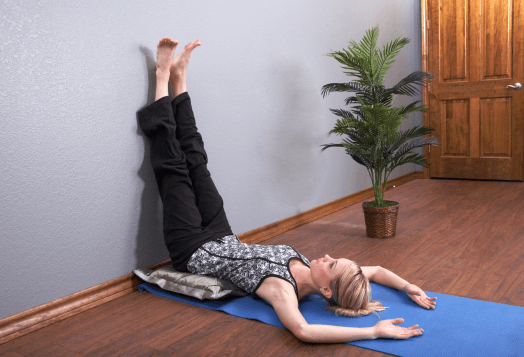 A woman practices Wall Legs Up (Viparita Karani)
