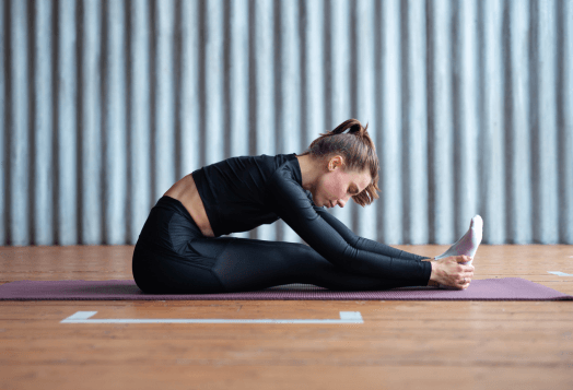 A woman practices Supported Forward Fold