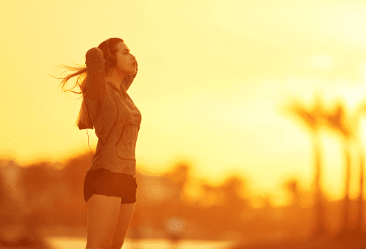Woman with headphones on during a golden hour sunset
