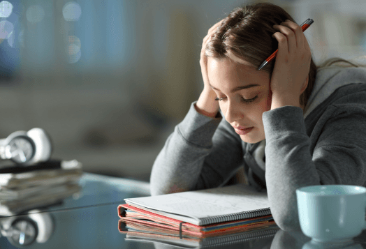 Frustrated woman studying with hands on her head