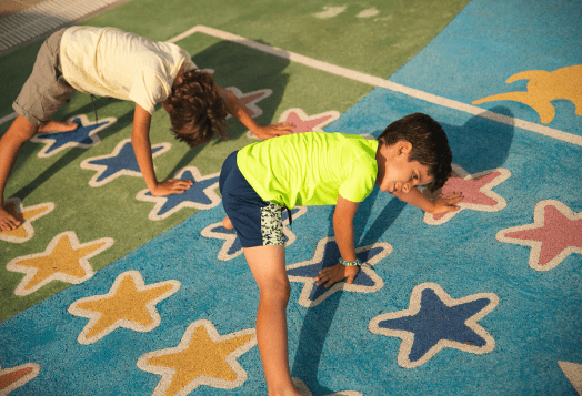 Two boys stretching on a colorful star-patterned mat