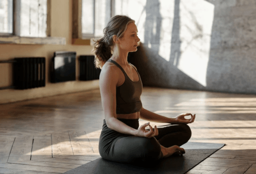 Woman meditating in lotus pose on a yoga mat