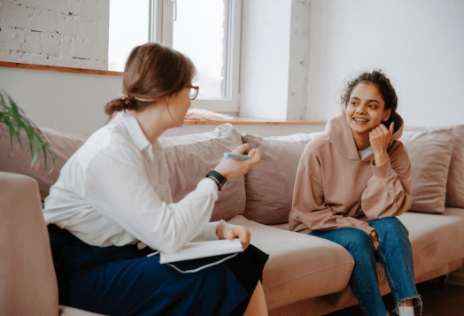 Woman smiling while talking to a therapist on a couch