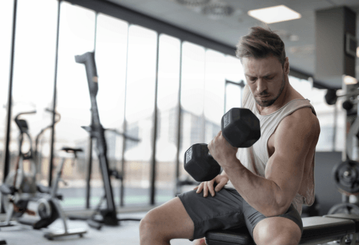 Man with a beard doing bicep curls with a dumbbell