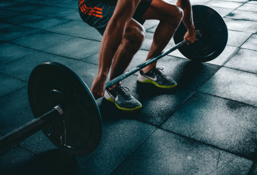 Man deadlifting barbell in a gym