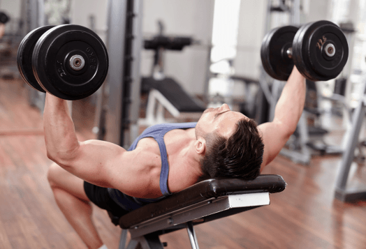 Man doing dumbbell press on a weight bench