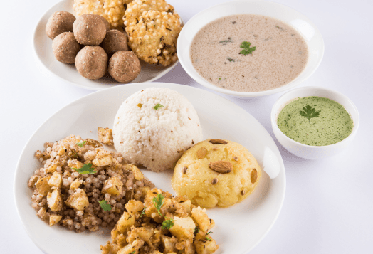 A variety of Indian fasting foods on a white plate