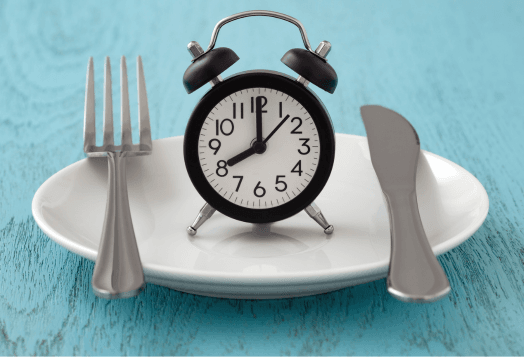 A black alarm clock on a white plate