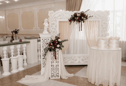 A beautifully decorated wedding arch with flowers and drapes