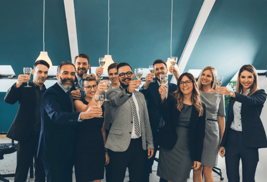 Group of business professionals raising glasses together in celebration