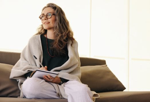 Woman journaling on a couch