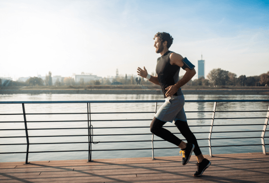 Man running along a waterfront promenade