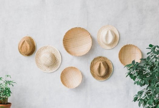 Woven hats and bowls hanging on a wall