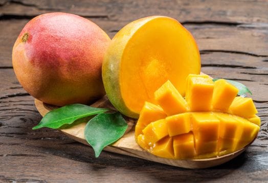 Sliced Alphonso mangoes on wood