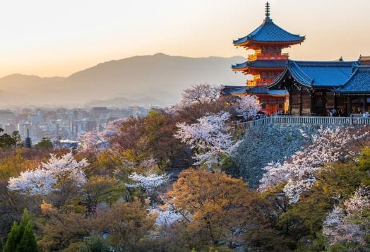 Temple with cherry blossoms in Kyoto hills