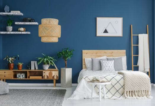 Blue bedroom with wooden furniture and plants