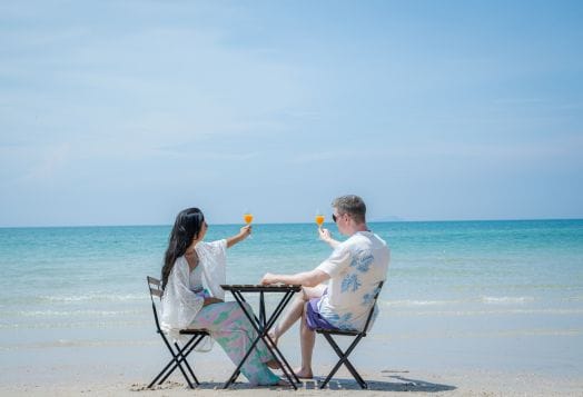 Couple toasting drinks by the sea