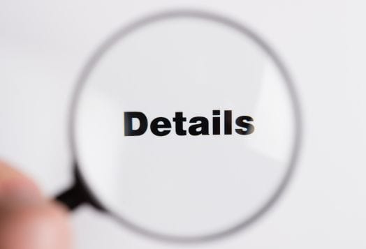 The word "Details" seen through a magnifying glass