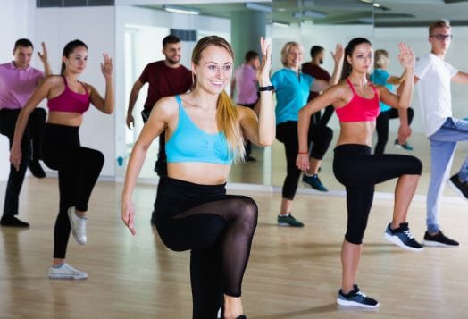 People in fitness class doing high knees