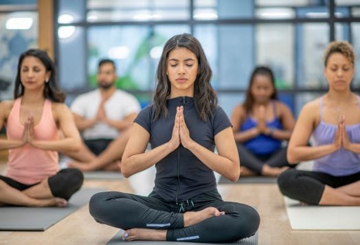 Group yoga class practicing mindfulness for stress relief