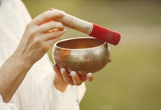 Hands playing Tibetan bowl for sound meditation healing