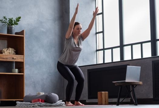 Woman doing Hatha Yoga postures in an online class