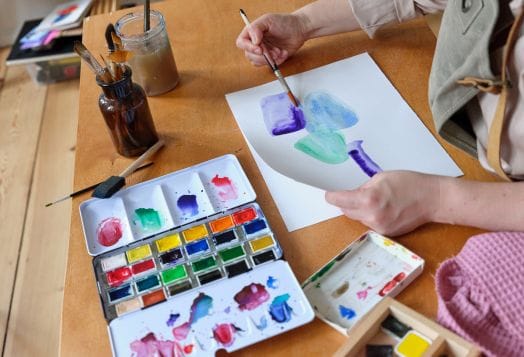 Hands painting with watercolors