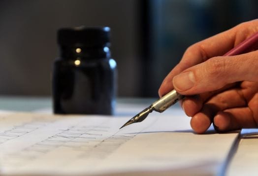 Hand writing with a dip pen and inkwell