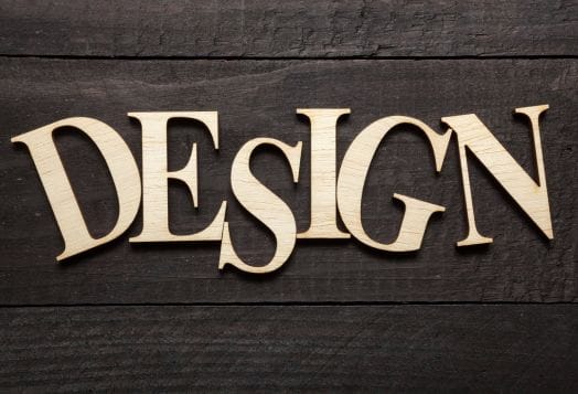 Word "DESIGN" in wooden letters on a dark wooden surface
