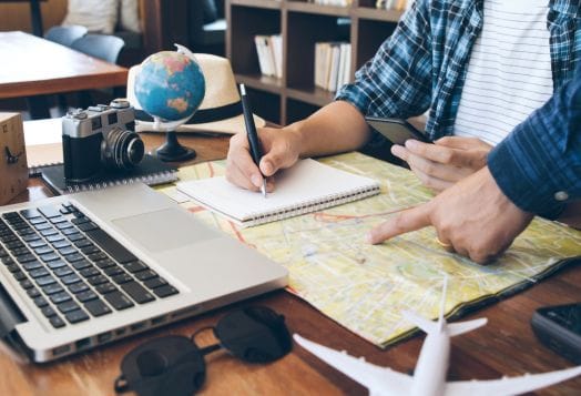 People planning a trip with map and laptop