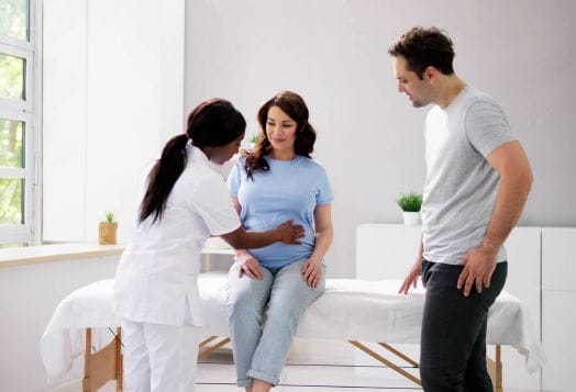 Healthcare professional examining a pregnant woman