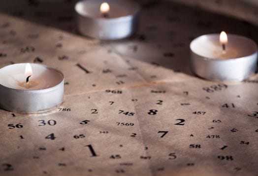 Numerology chart with lit tea light candles