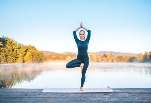 Woman practicing Tree Pose for yoga balance and joy