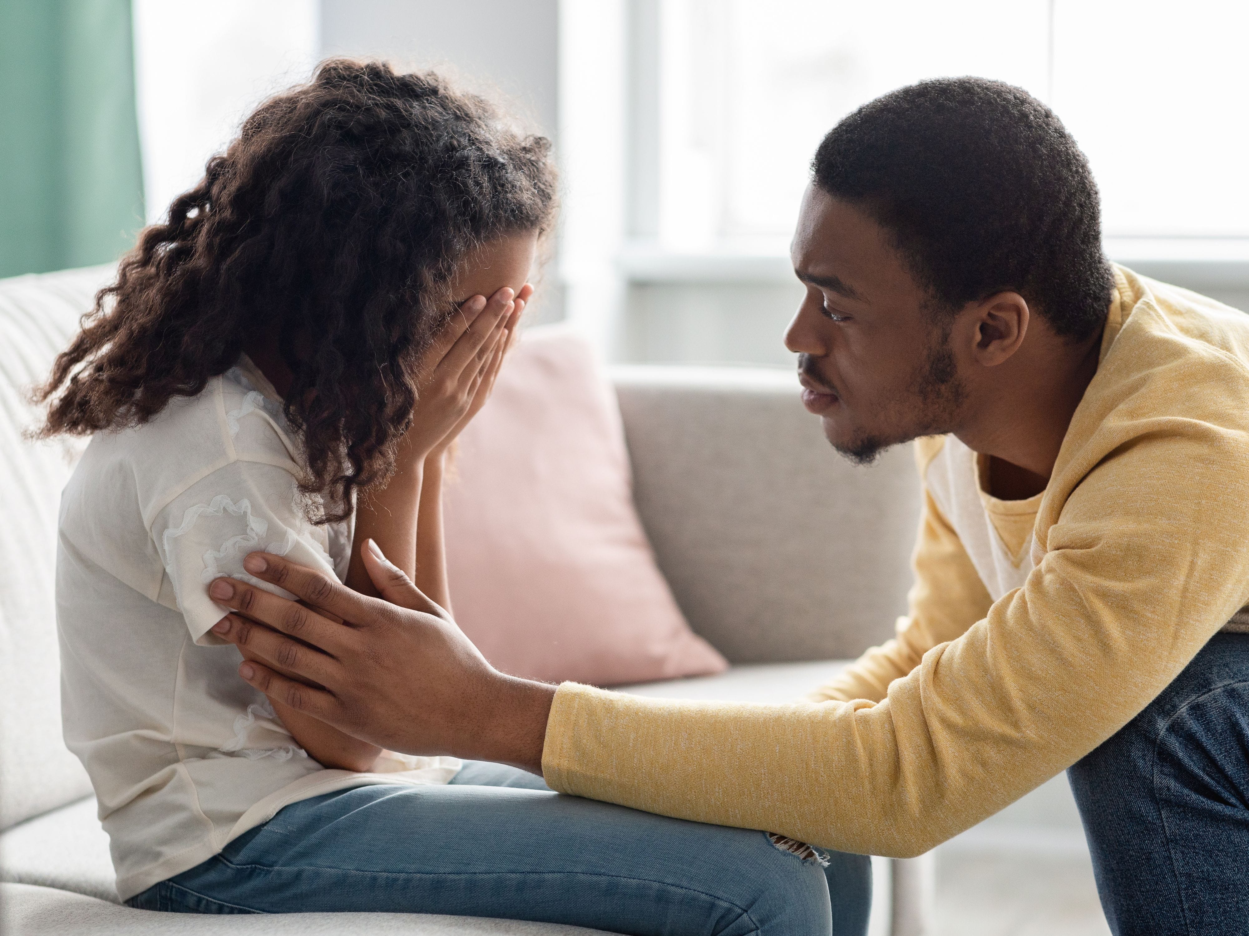 Father comforting his upset daughter at home