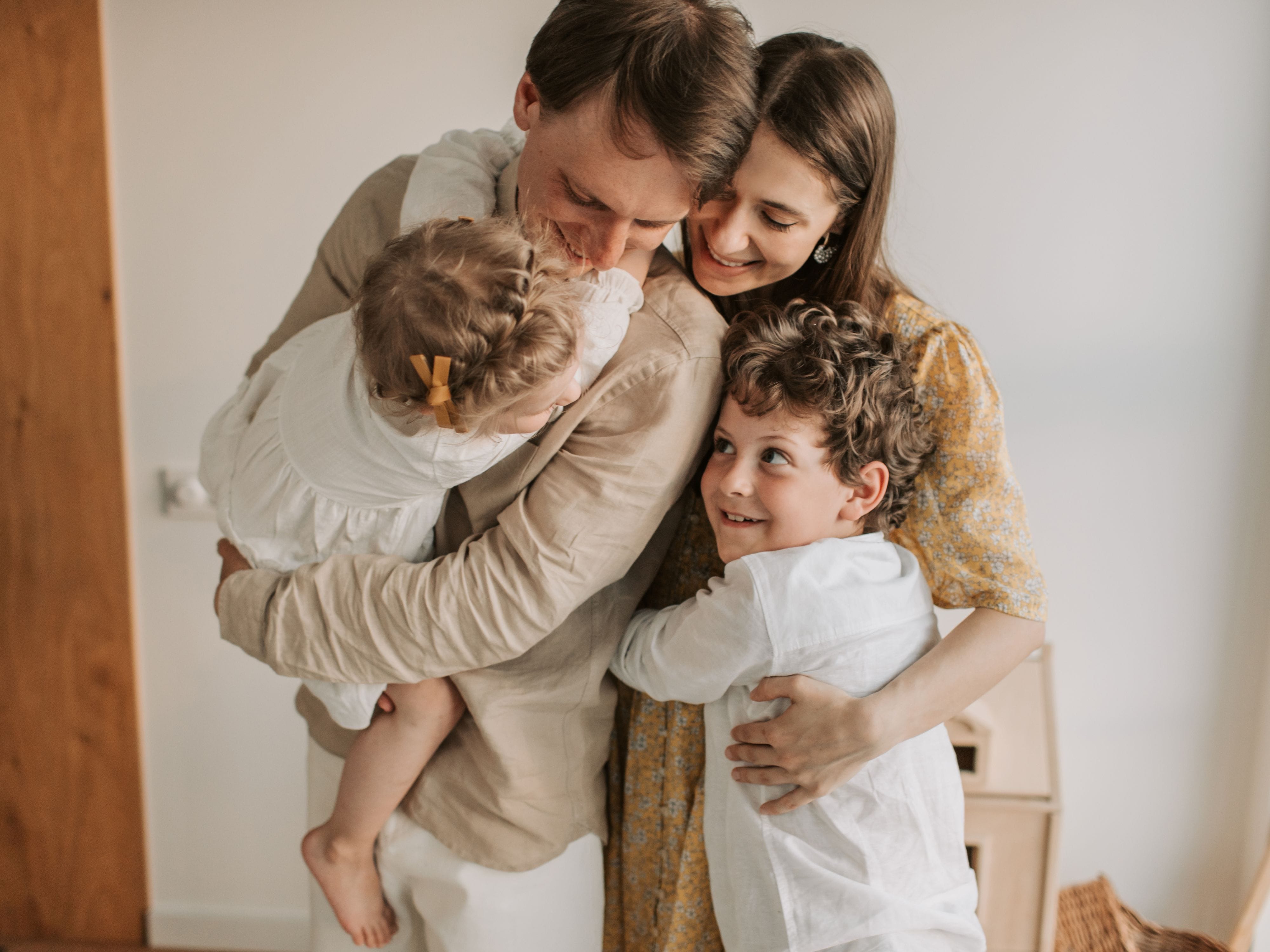 Happy family sharing a warm group hug at home
