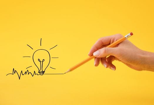 Hand drawing a lightbulb idea