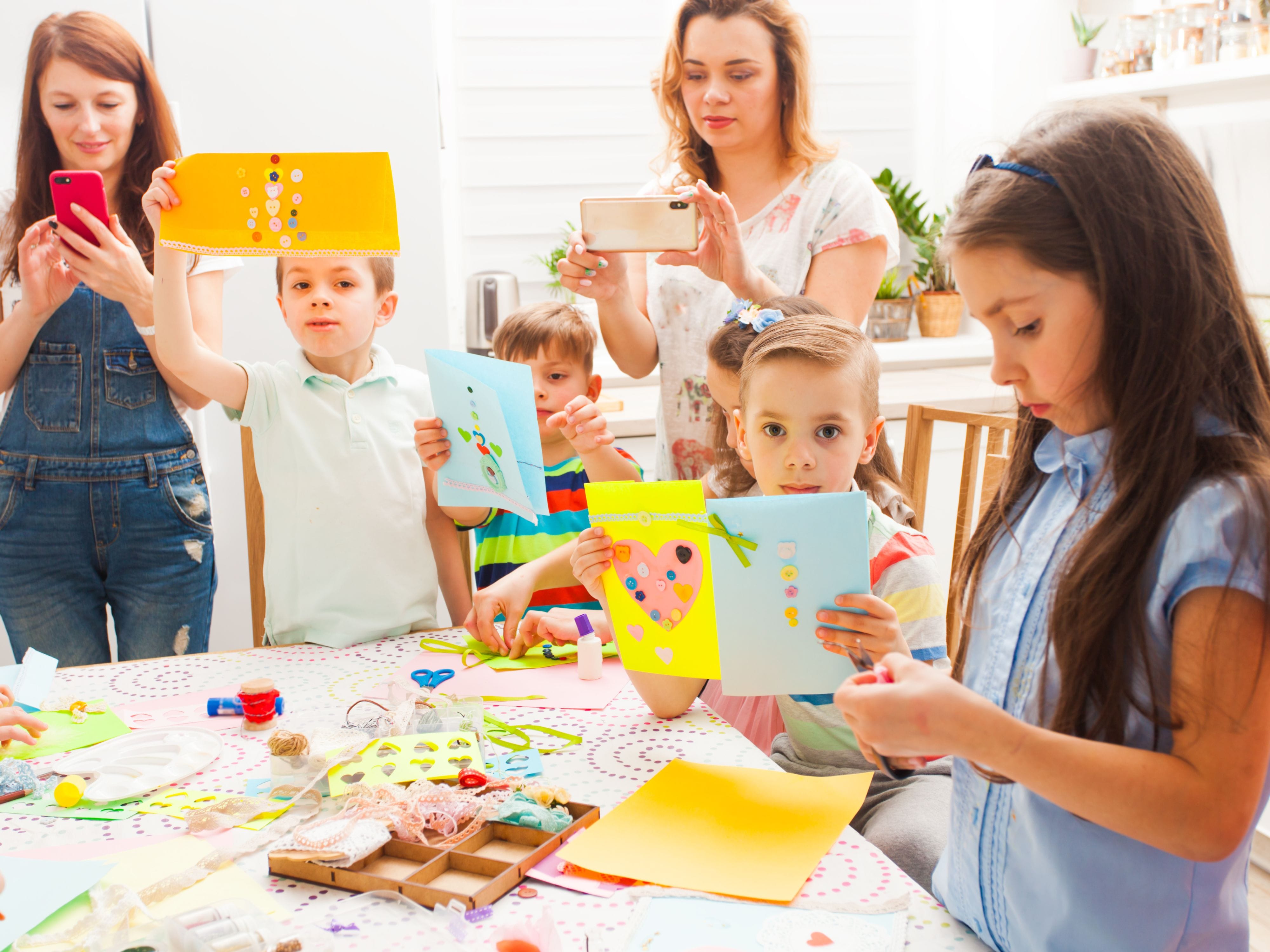 Kids showing crafts, adults taking photos