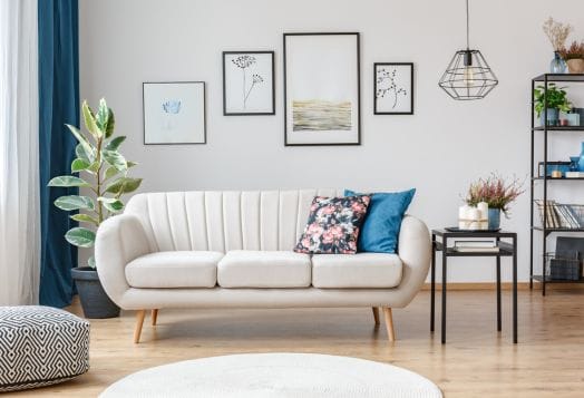Modern white sofa with pillows and art