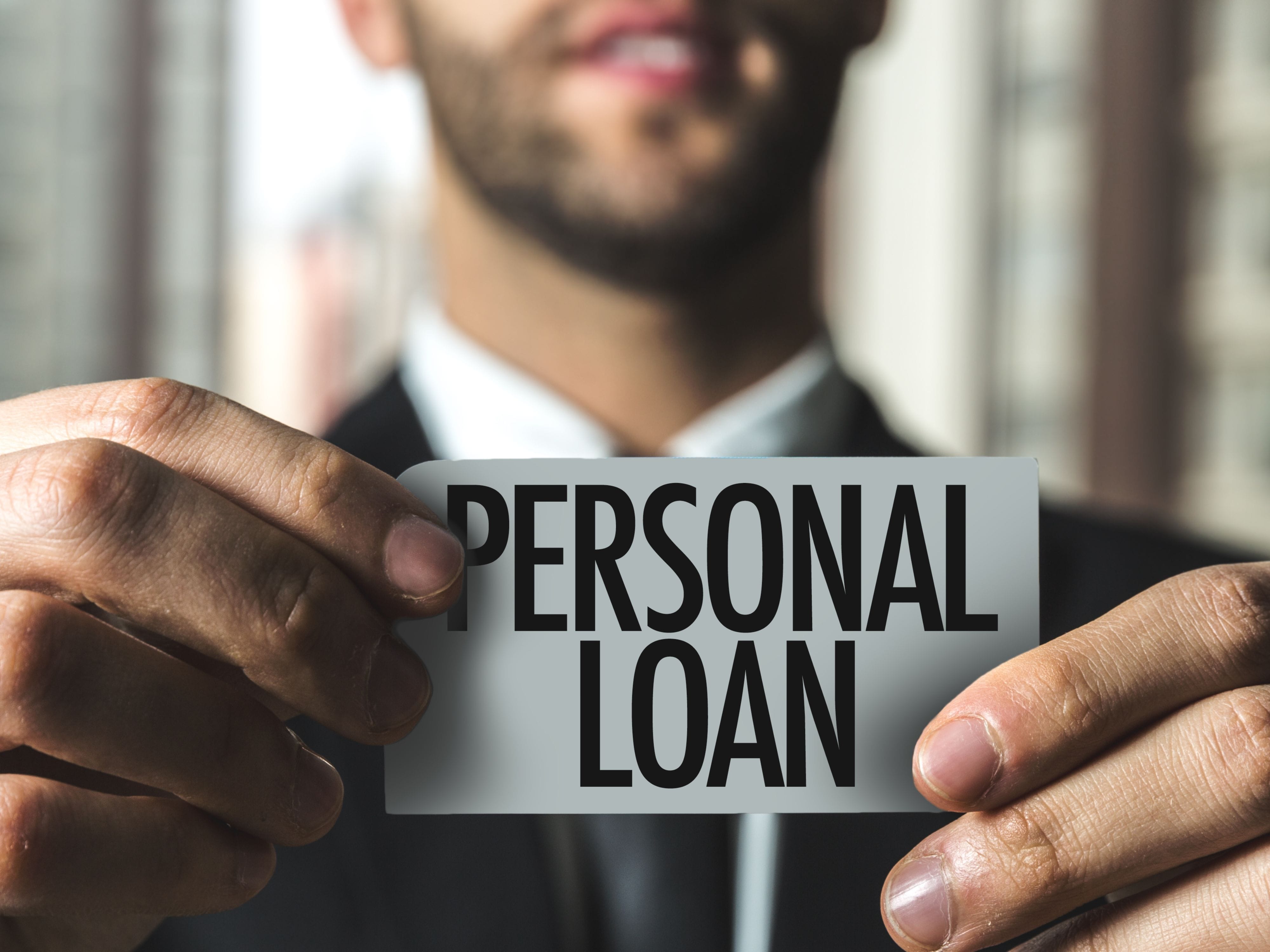 Hands holding "Personal Loan" card